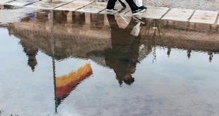 Poussette compacte avec nacelle et panier sur un trottoir urbain en plein jour