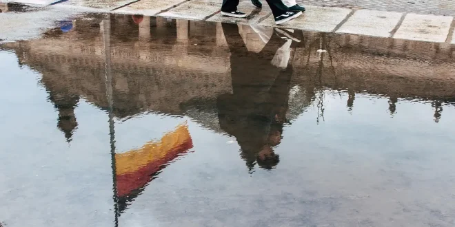 Poussette compacte avec nacelle et panier sur un trottoir urbain en plein jour