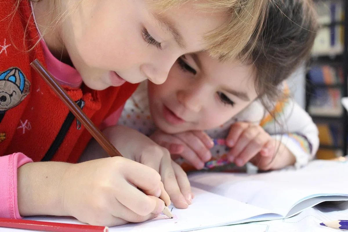 Parent discutant calmement avec un enseignant, carnet et notes sur la table