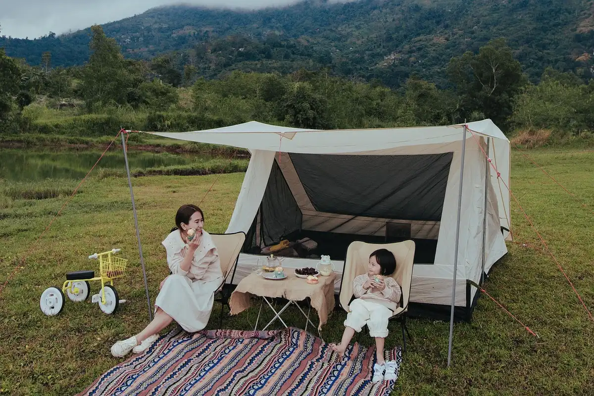 Tente de camping avec lit de voyage posé près de l'entrée
