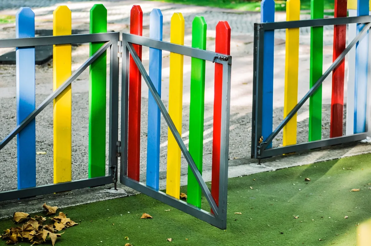 Enfants de maternelle jouant dehors en groupe, observant les interactions sociales