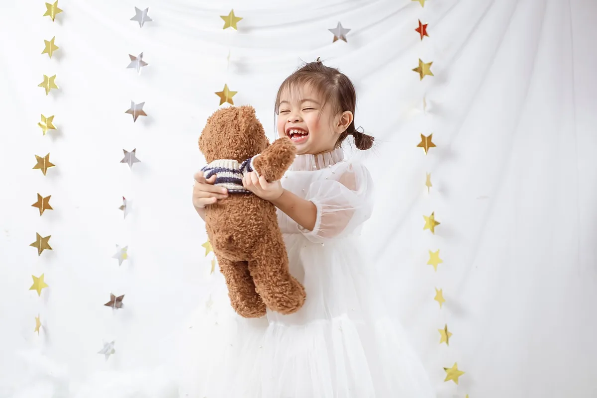 Tout-petit plaçant une peluche dans un bac à jouets accessible