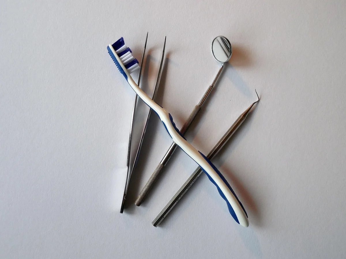 Brosse à dents et carnet de grossesse posés près d'un lavabo en pleine journée