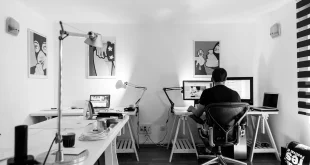 Bureau en journée avec ordinateur portable, documents légaux et une main indiquant un paragraphe