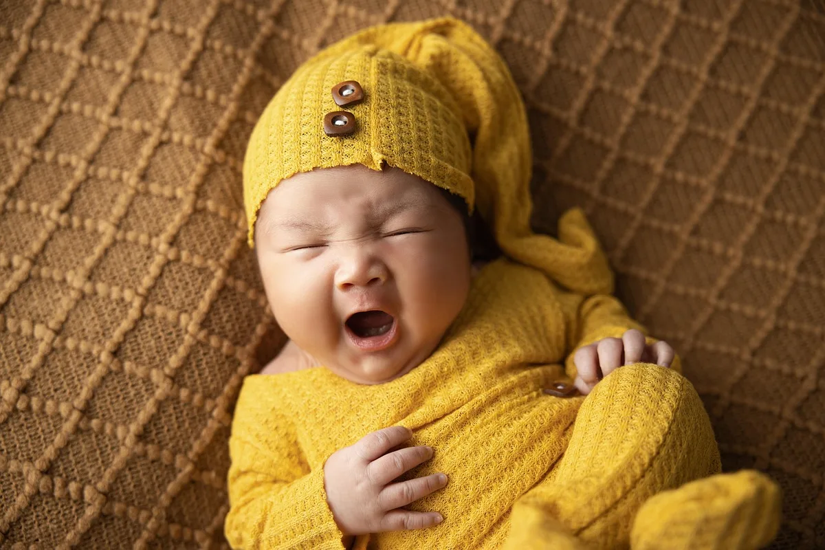 Bébé agrippant un doigt lors d'un réflexe primitif